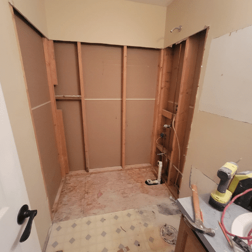 Bathroom renovation framing stage showing plumbing and wall preparation by Homes by Covenant
