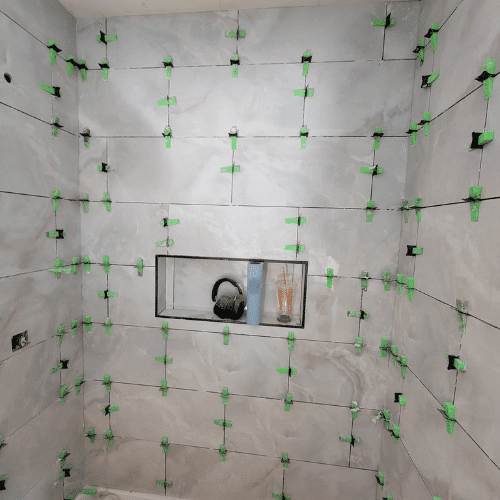 Bathroom wall tile installation in progress during remodel by Homes by Covenant renovation specialists