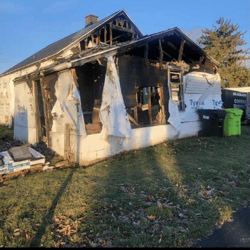Severe exterior fire damage prior to cleanup and reconstruction by Homes by Covenant in Central New York