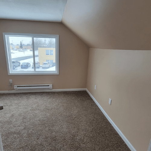 Upstairs bedroom remodel showing updated trim, carpet, and windows by Homes by Covenant