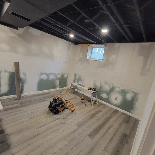 Basement renovation in progress showing new drywall installation and framing by Homes by Covenant