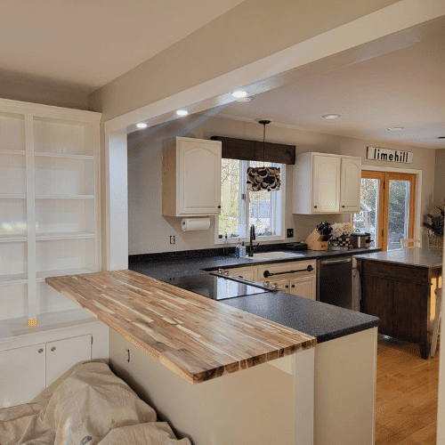 Kitchen renovation in progress showing countertop installation and cabinet refinishing by Homes by Covenant