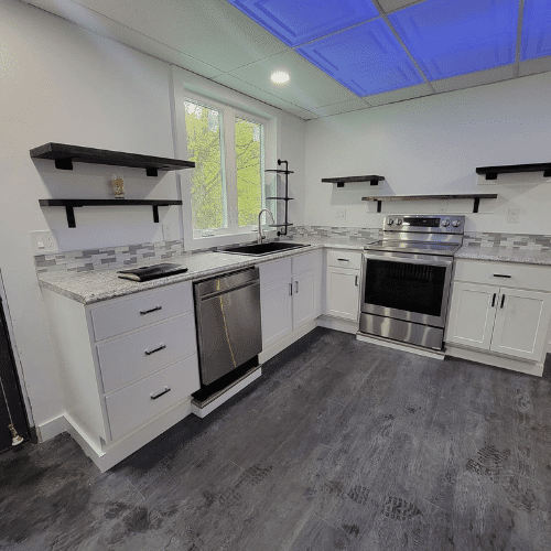 Modern kitchen remodel with updated flooring and appliances designed by Homes by Covenant