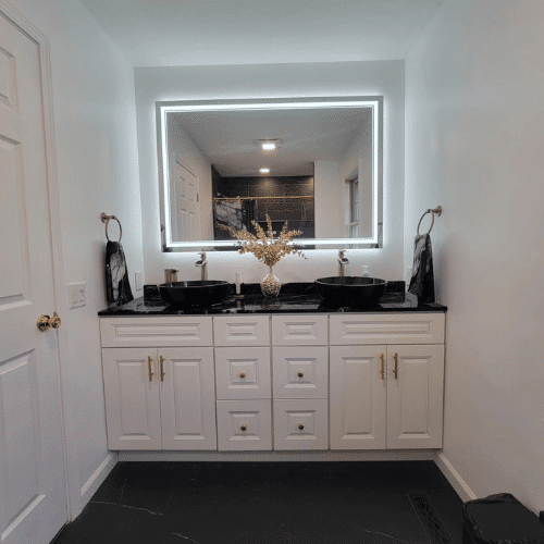 Completed bathroom remodel with elegant white cabinetry and dual sinks installed by Homes by Covenant in Central New York