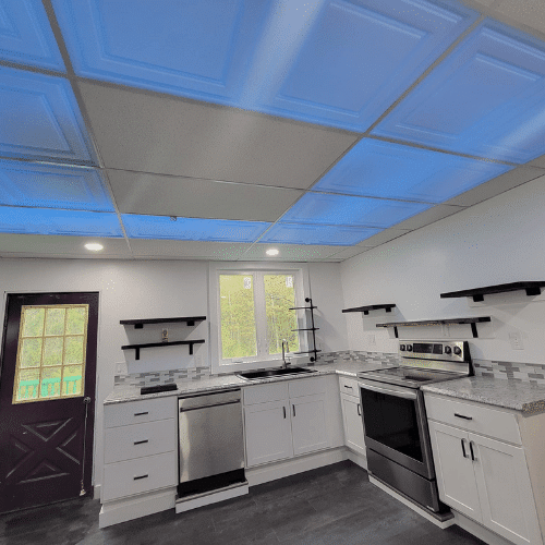 Fully renovated kitchen featuring new cabinets, backsplash, and lighting completed by Homes by Covenant