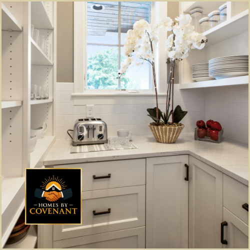 Bright white kitchen cabinetry with custom shelving and an organized workspace.