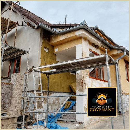 Exterior home undergoing restoration with damaged stucco, exposed framing, and scaffolding prepared for repair work.