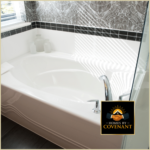 Bathroom remodel featuring a large soaking tub with marble tile surround and modern fixtures.