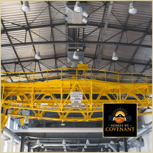 “Modular home sections being built inside a climate-controlled factory with precision equipment.”