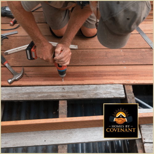 Technician repairing damaged wooden deck boards using a drill and carpentry tools.