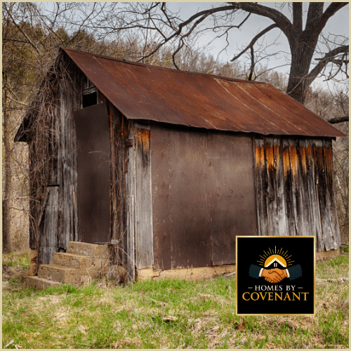 Old weathered shed with rusted metal siding and aged wooden framing.