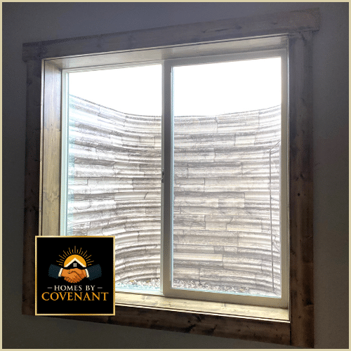 Basement egress window with exterior well and safety grading.