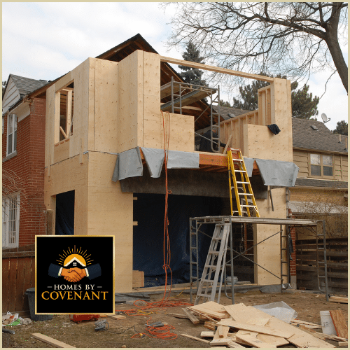 Two-story home addition under construction with scaffolding and new framing.
