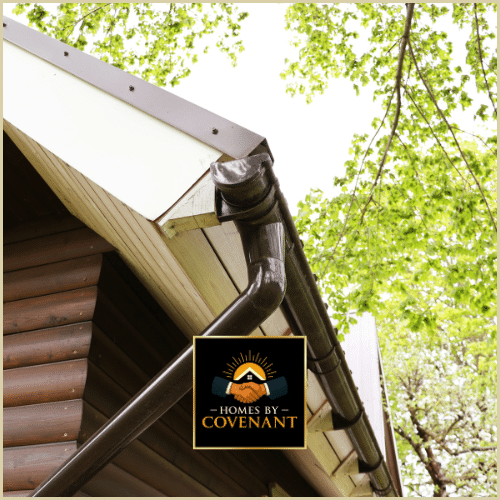 Newly installed dark gutter system on a home’s exterior with wood siding.