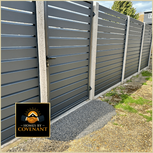 Modern composite fence installation with gray panel sections and gravel base.
