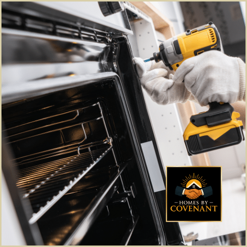 Technician installing a built-in kitchen oven during a remodeling project.
