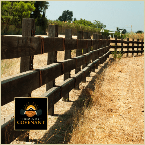 Worker setting a metal fence post to reinforce fence structure.