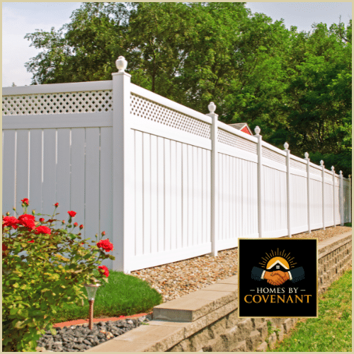 Leveled ground and prepared fence line beside white vinyl fence.