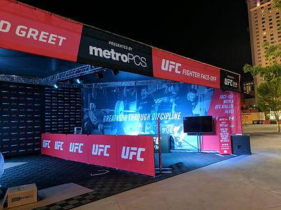 Branded meet-and-greet pavilion with red fascia, counter, and queue lanes for UFC fan experience.