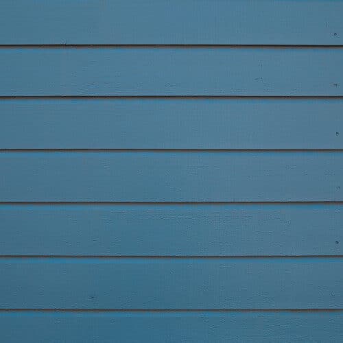 Blue horizontal lap siding with smooth painted planks.